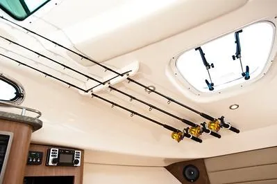 Slide: The Image of 2025 Boston Whaler 285 Conquest cabin interior with fishing rod holders and ceiling hatch. - 9