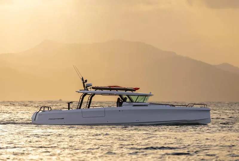 Slide: The Image of 2025 Axopar 45 Cross Top boat cruising at sunset on calm waters. - 0