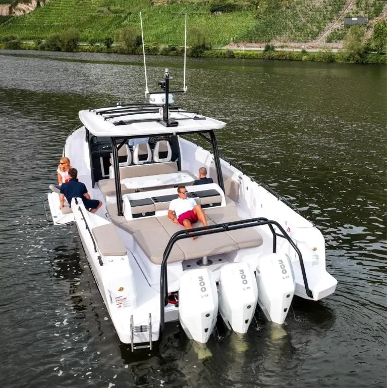 Slide: The Image of 2025 Axopar 45 Cross Top boat cruising on a serene river with passengers relaxing. - 5
