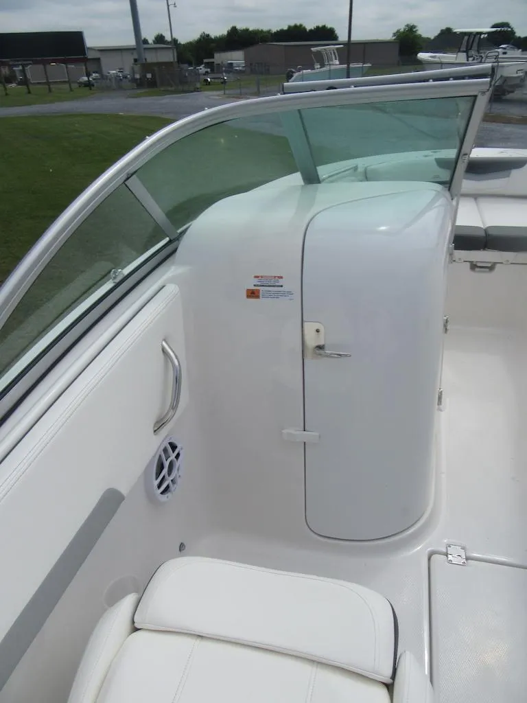 Slide: The Image of 2025 Robalo R207 Dual Console interior with white seating and storage compartment. - 10