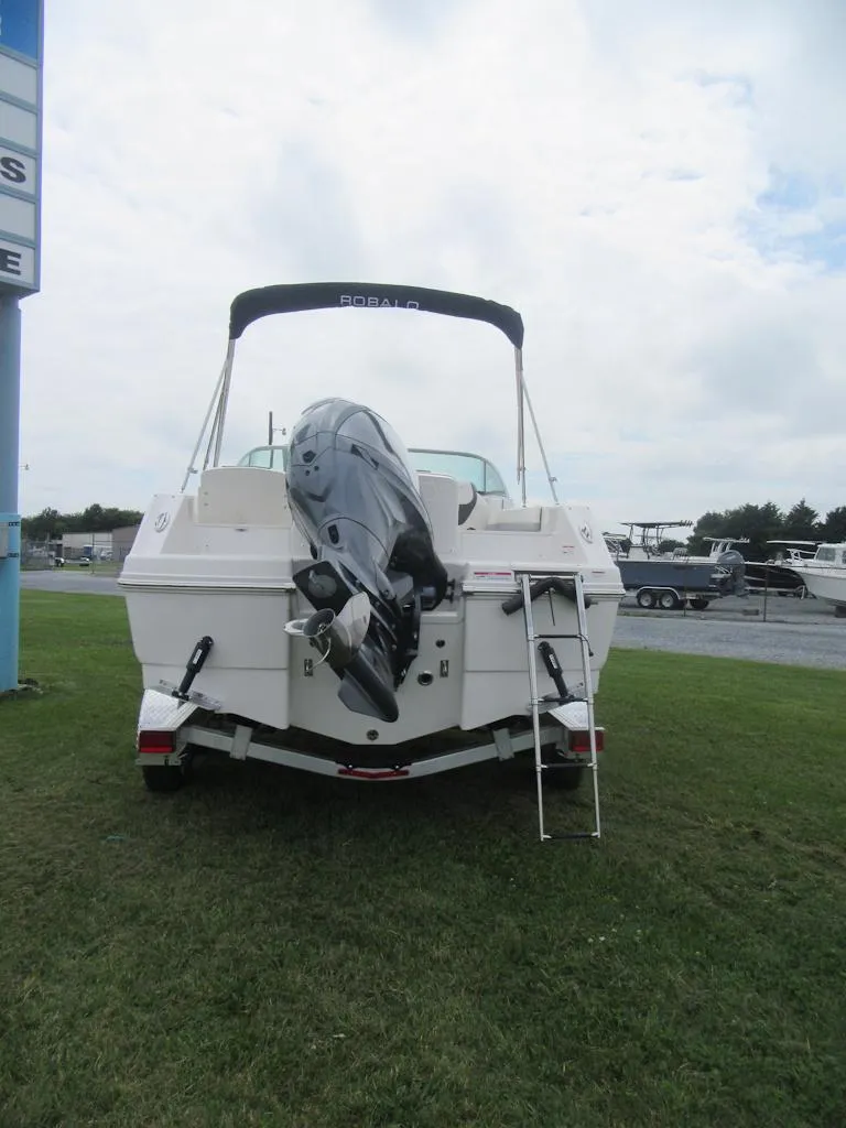 Slide: The Image of 2025 Robalo R207 Dual Console boat with outboard motor, rear view on grass. - 3