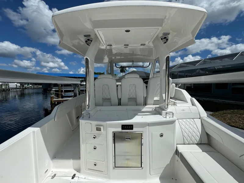 Slide: The Image of 2022 Regal 33 SAV boat interior with seating and storage, docked under a blue sky. - 11
