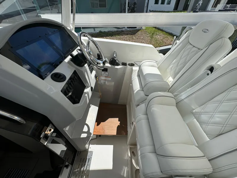 Slide: The Image of Interior of 2022 Regal 33 SAV boat with white leather seating and modern dashboard. - 13