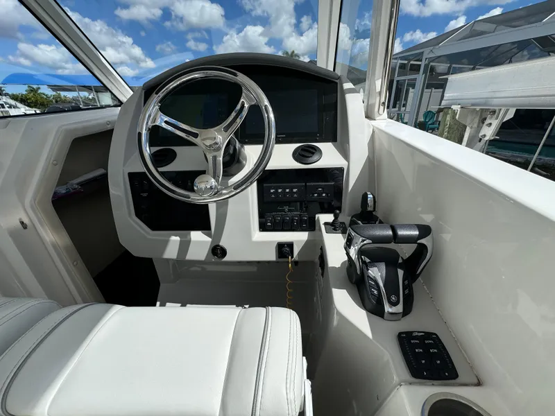 Slide: The Image of 2022 Regal 33 SAV boat cockpit with steering wheel and control panel. - 14