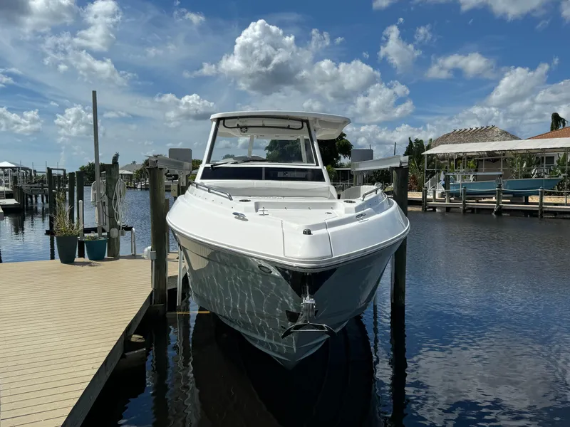 Slide: The Image of 2022 Regal 33 SAV boat docked on a sunny day with blue skies. - 2