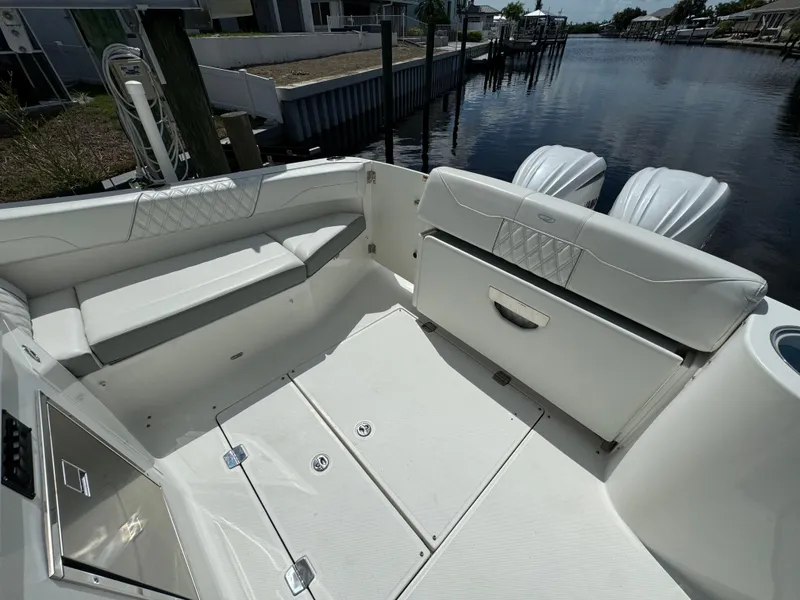 Slide: The Image of 2022 Regal 33 SAV boat interior with white seating and dual outboard motors. - 6