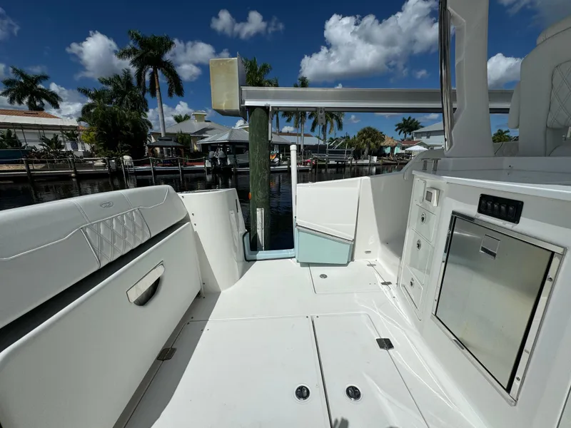 Slide: The Image of 2022 Regal 33 SAV boat interior with seating and storage, docked under a clear blue sky. - 8