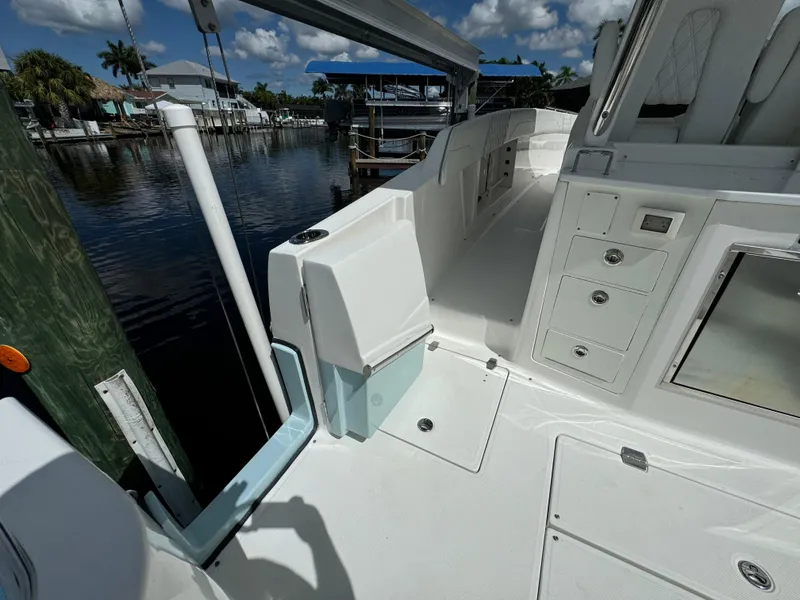 Slide: The Image of 2022 Regal 33 SAV boat deck with storage compartments, docked by a serene waterfront. - 9