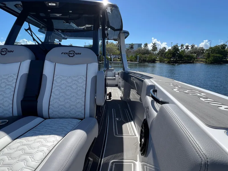 Slide: The Image of 2023 Fountain 38 SCX boat interior with luxurious seating on a sunny day. - 13