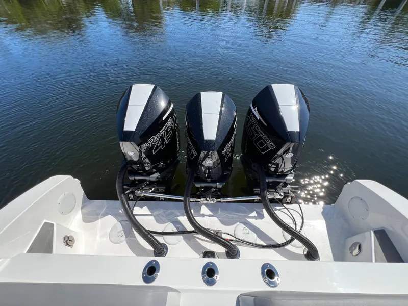 Slide: The Image of 2023 Fountain 38 SCX boat with triple outboard engines on calm water. - 26