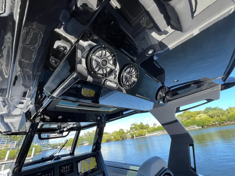 Slide: The Image of 2023 Fountain 38 SCX boat interior with advanced audio system, sleek design, and scenic water view. - 31