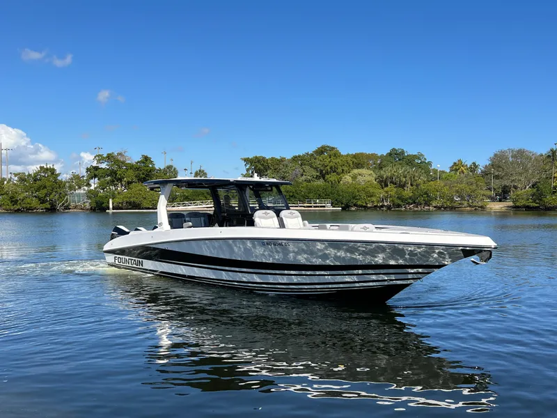 Slide: The Image of 2023 Fountain 38 SCX boat cruising on a calm lake under a clear blue sky. - 4
