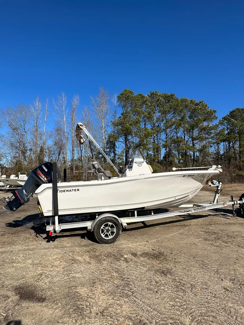 Slide: The Image of 2020 Tidewater 1900CC Bay Boat on trailer, parked outdoors under clear blue sky. - 4
