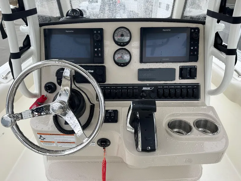 Slide: The Image of 2022 Boston Whaler 230 Outrage helm with dual displays and steering wheel. - 2