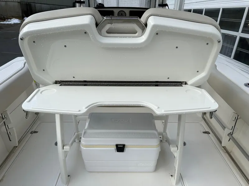 Slide: The Image of 2022 Boston Whaler 230 Outrage boat with open storage compartment and cooler. - 8