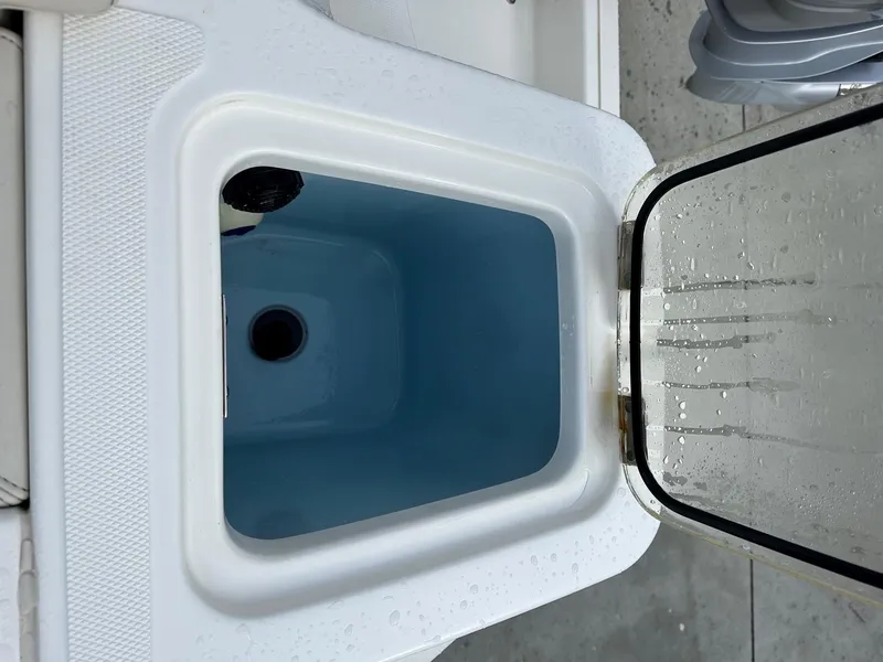 Slide: The Image of Open storage compartment on 2022 Boston Whaler 230 Outrage boat, showing interior details. - 9