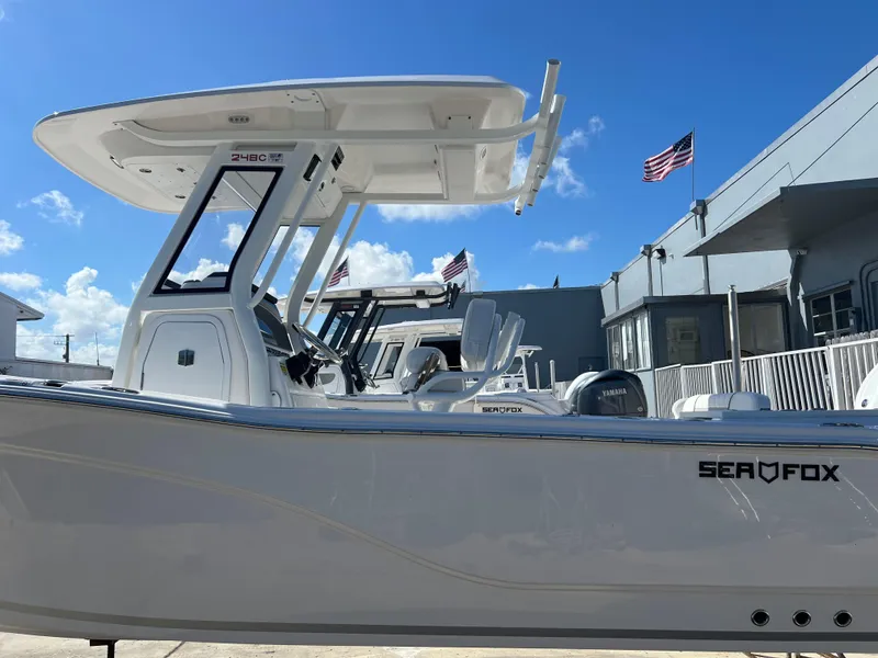 Slide: The Image of 2025 Sea Fox 248 Commander boat with T-top, docked under a clear blue sky. - 2