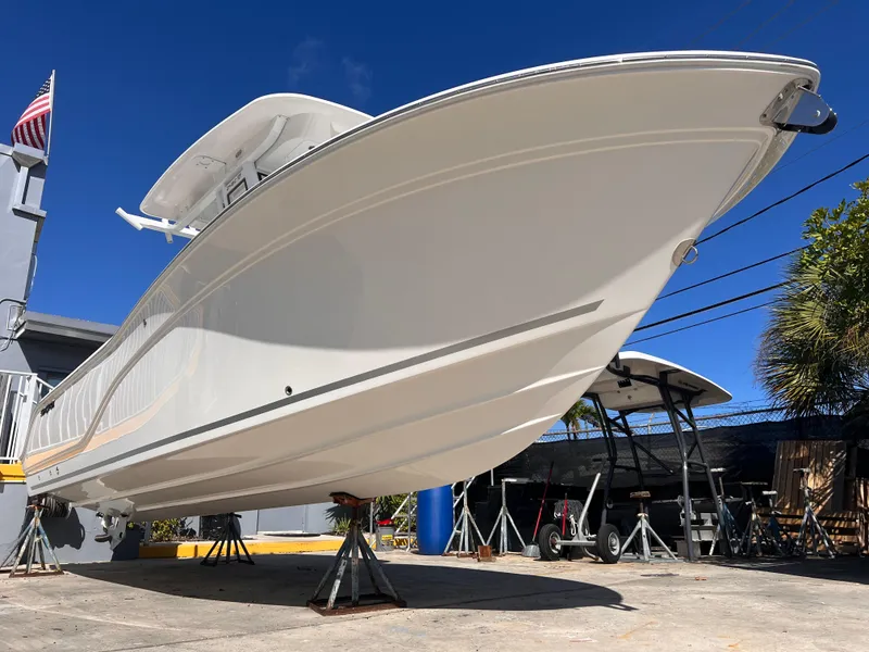 Slide: The Image of 2025 Sea Fox 248 Commander boat on stands, viewed from below, with clear blue sky. - 8