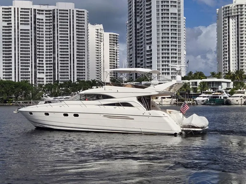 The Image of 1998 Viking Princess 56 Sport Cruiser yacht on water, surrounded by buildings and palm trees. - 0