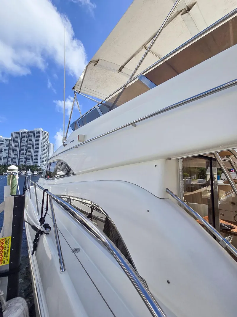 Slide: The Image of 1998 Viking Princess 56 Sport Cruiser docked under a clear blue sky. - 10