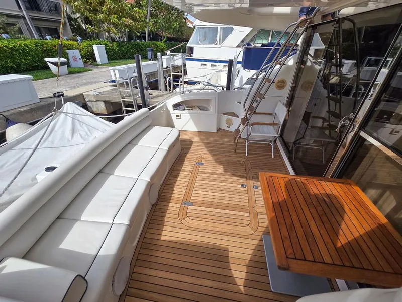 Slide: The Image of 1998 Viking Princess 56 Sport Cruiser yacht with teak deck and white seating area. - 15