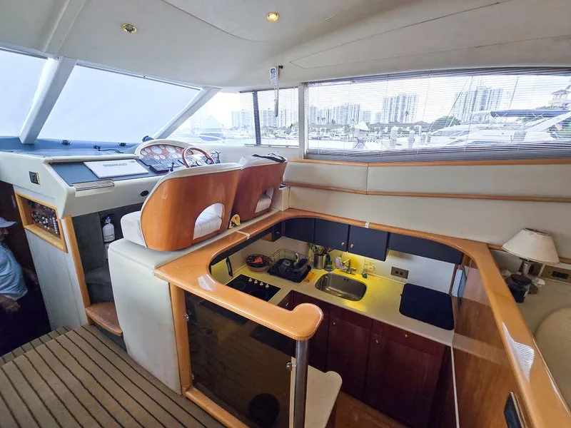 Slide: The Image of 1998 Viking Princess 56 Sport Cruiser interior with helm, kitchen, and seating area. - 37