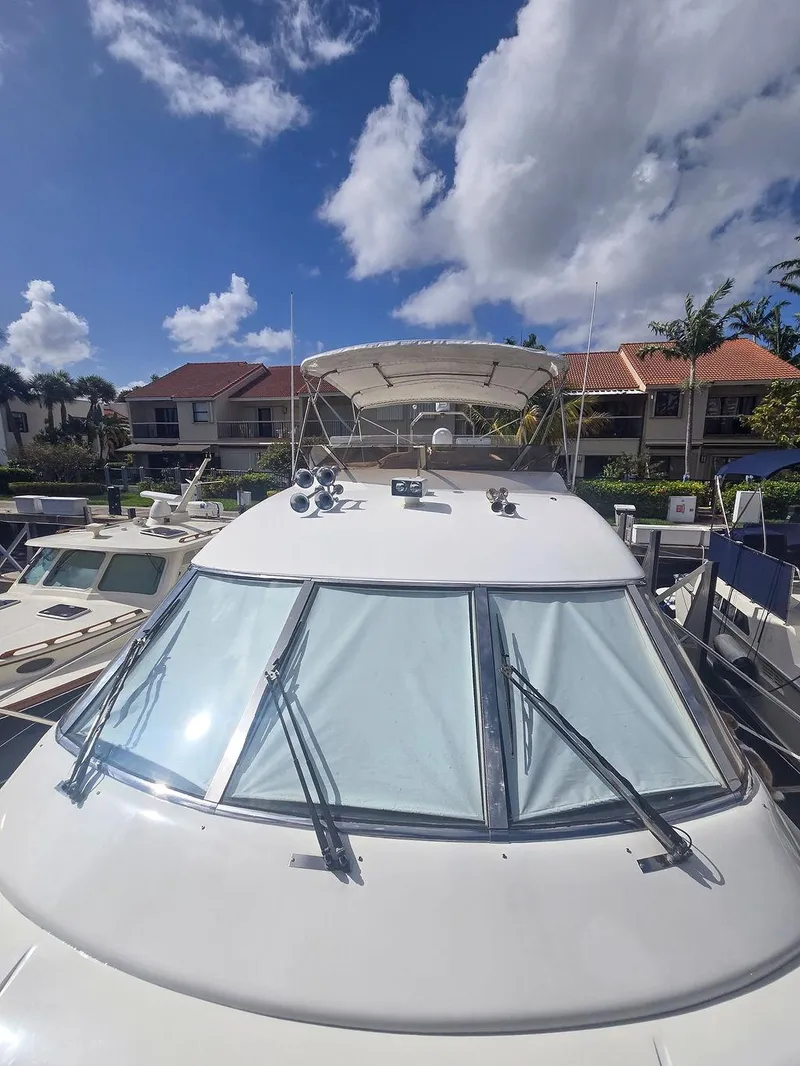 Slide: The Image of 1998 Viking Princess 56 Sport Cruiser docked under a bright blue sky. - 4