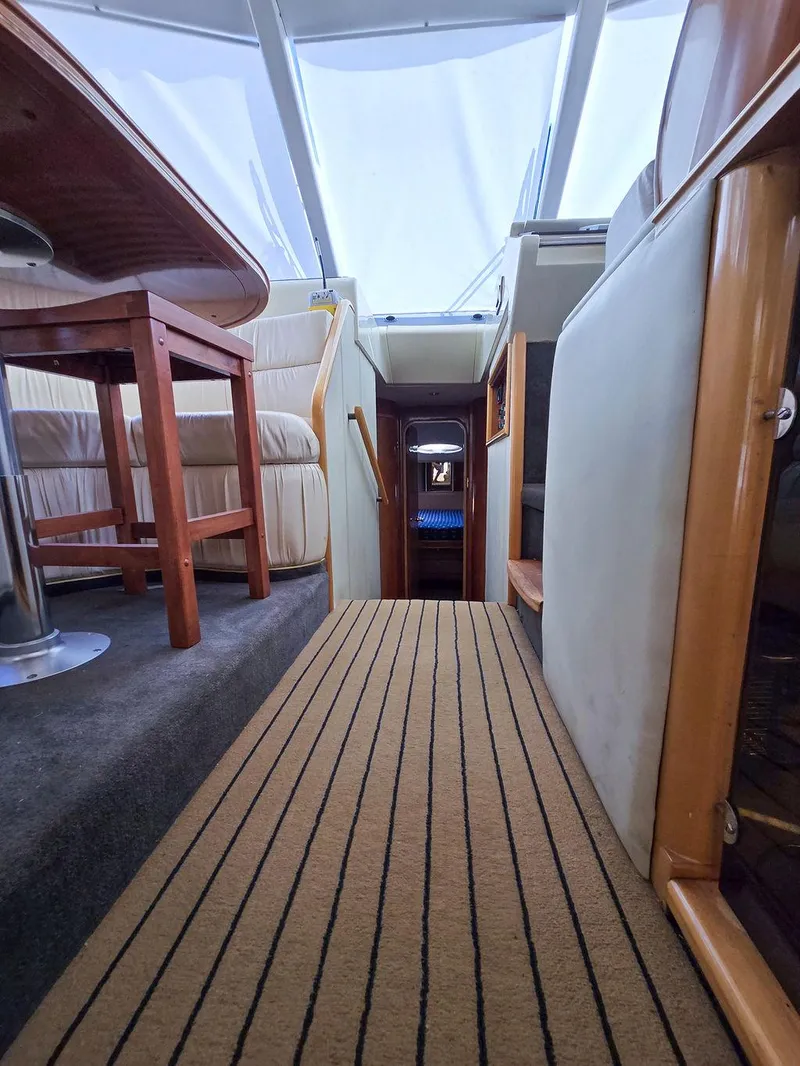 Slide: The Image of Interior view of 1998 Viking Princess 56 Sport Cruiser, featuring elegant wood and carpeted flooring. - 41