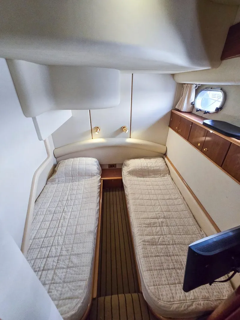 Slide: The Image of 1998 Viking Princess 56 Sport Cruiser cabin with twin beds and wooden cabinetry. - 44
