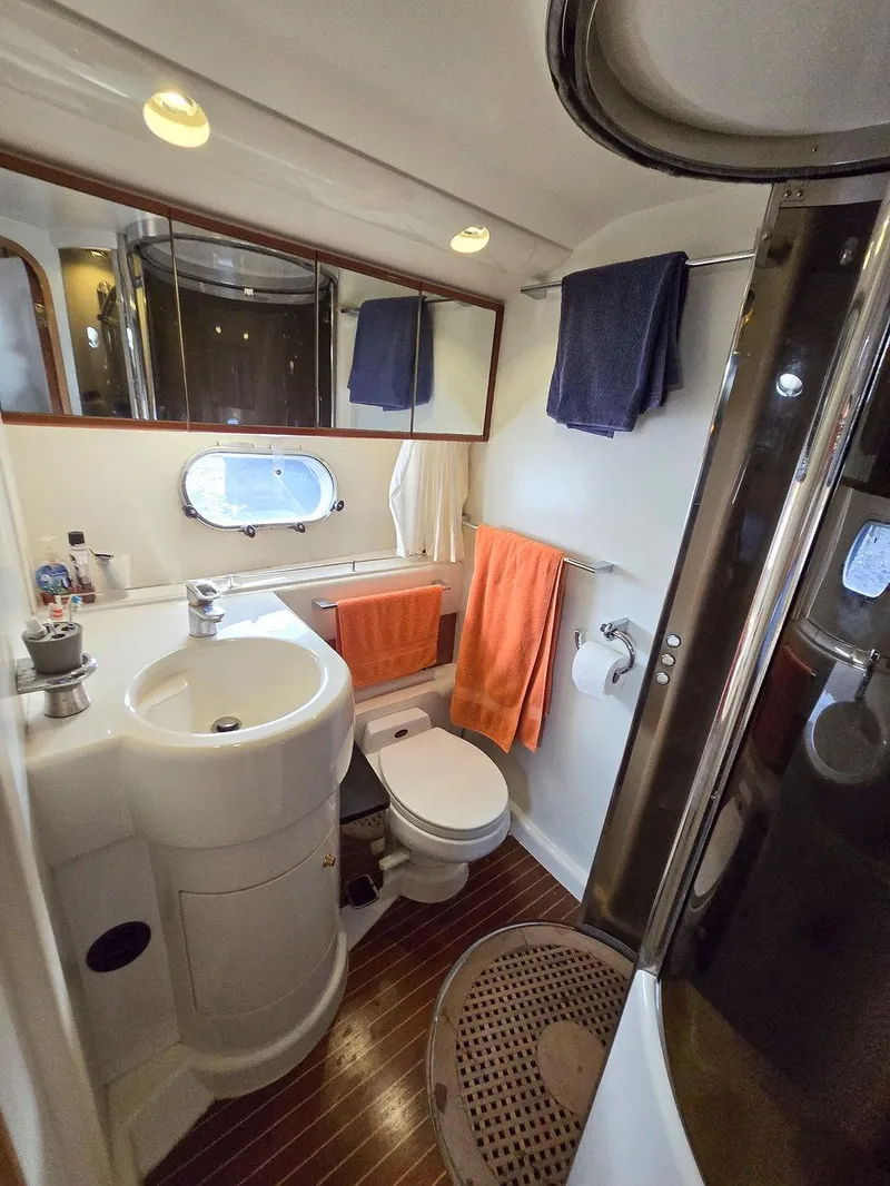 Slide: The Image of 1998 Viking Princess 56 Sport Cruiser bathroom with sink, toilet, shower, and towels. - 46