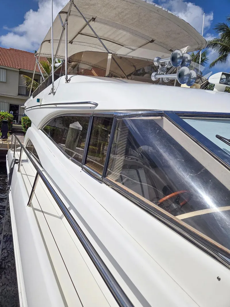 Slide: The Image of 1998 Viking Princess 56 Sport Cruiser, sleek design, docked under clear blue sky. - 7