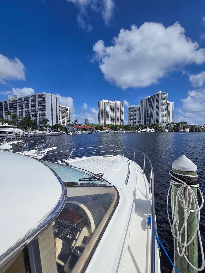 Slide: The Image of 1998 Viking Princess 56 Sport Cruiser docked with city skyline in background. - 8