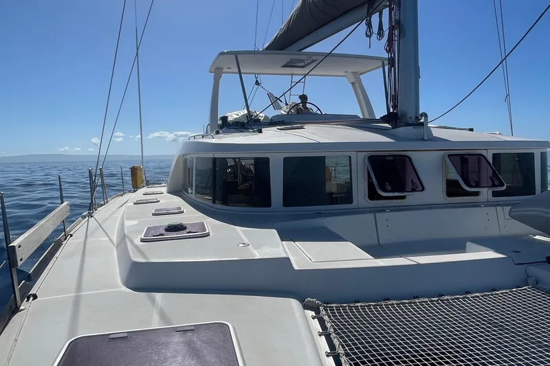Slide: The Image of 2010 Lagoon 440 catamaran sailing on open sea under clear blue sky. - 11