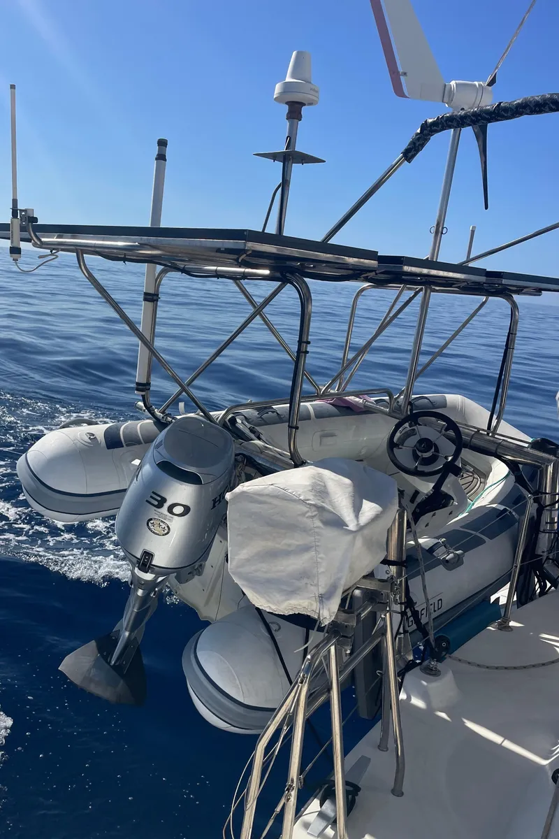 Slide: The Image of Lagoon 440 catamaran, 2010 model, with dinghy and outboard motor on calm sea. - 42