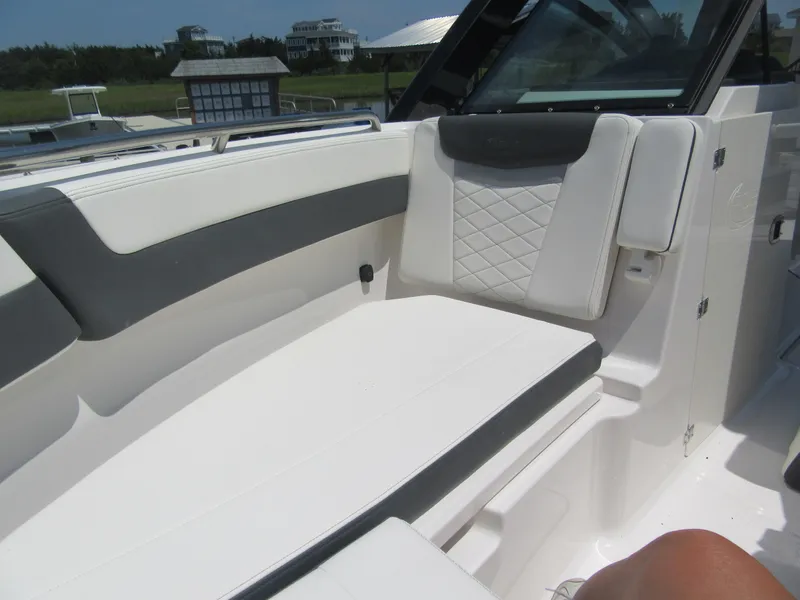 Slide: The Image of 2025 Robalo R257 Dual Console boat interior with white and gray seating. - 11
