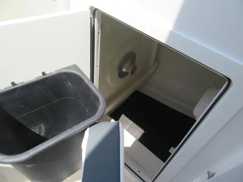 Slide: The Image of 2025 Robalo R257 Dual Console storage compartment with black bin and interior view. - 15