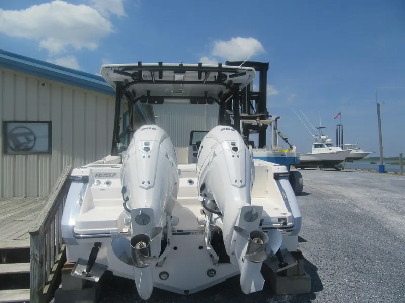 Slide: The Image of 2025 Robalo R257 Dual Console boat with twin engines at a marina dock. - 2