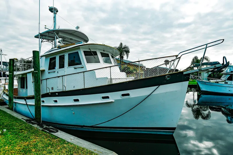 The Image of 1984 Kadey-Krogen Krogen 42 Trawler docked by the water, overcast sky. - 0