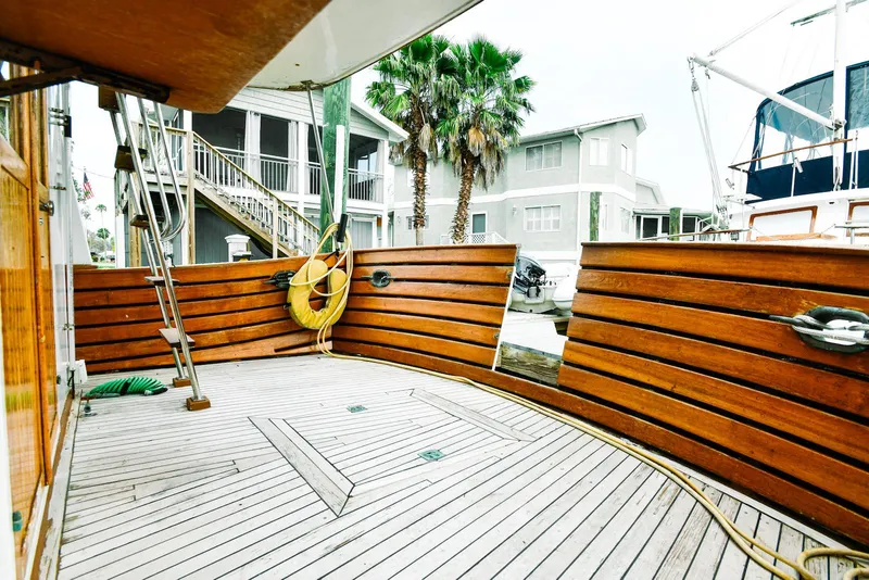 Slide: The Image of 1984 Kadey-Krogen Krogen 42 Trawler deck with wooden railings and docked setting. - 10