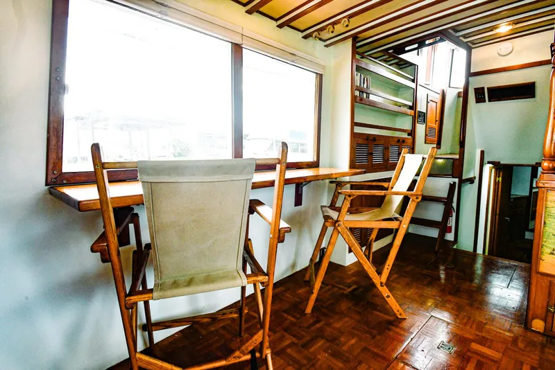 Slide: The Image of 1984 Kadey-Krogen Krogen 42 Trawler interior with wooden chairs and large windows. - 19