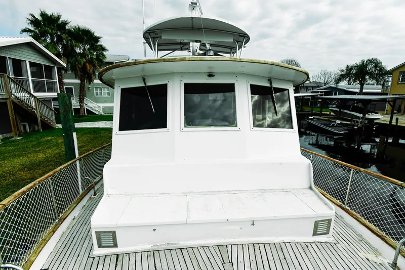 Slide: The Image of 1984 Kadey-Krogen Krogen 42 Trawler docked, showcasing its spacious deck and classic design. - 2