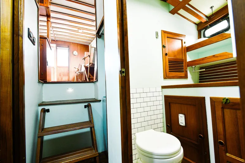 Slide: The Image of 1984 Kadey-Krogen Krogen 42 Trawler interior with wooden cabinetry and compact bathroom. - 26