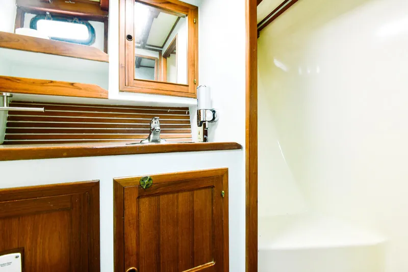 Slide: The Image of 1984 Kadey-Krogen Krogen 42 Trawler bathroom with wooden cabinets and sink. - 27