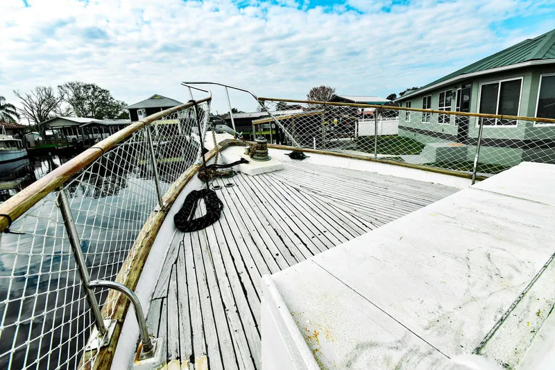 Slide: The Image of 1984 Kadey-Krogen Krogen 42 Trawler deck with railing, docked near waterfront homes. - 4