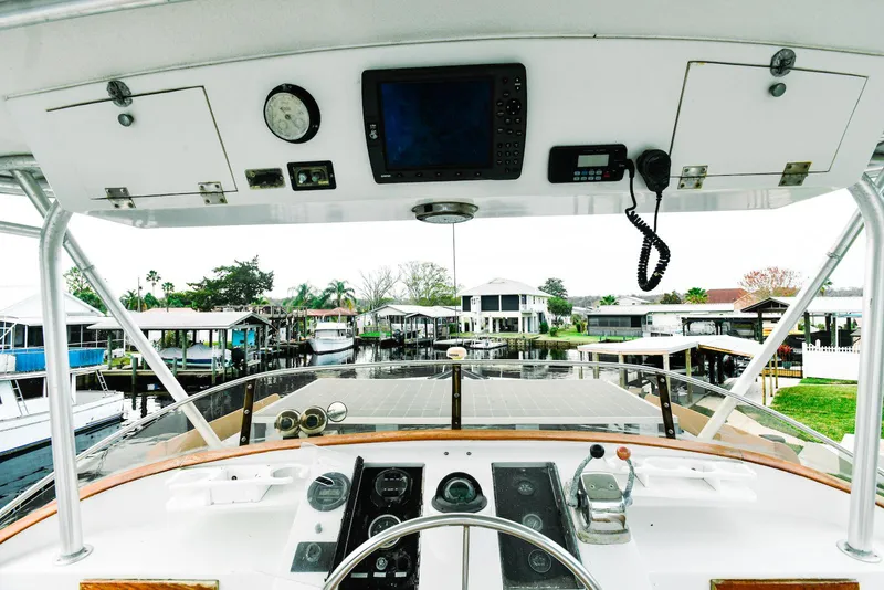 Slide: The Image of 1984 Kadey-Krogen Krogen 42 Trawler helm with navigation equipment and marina view. - 7