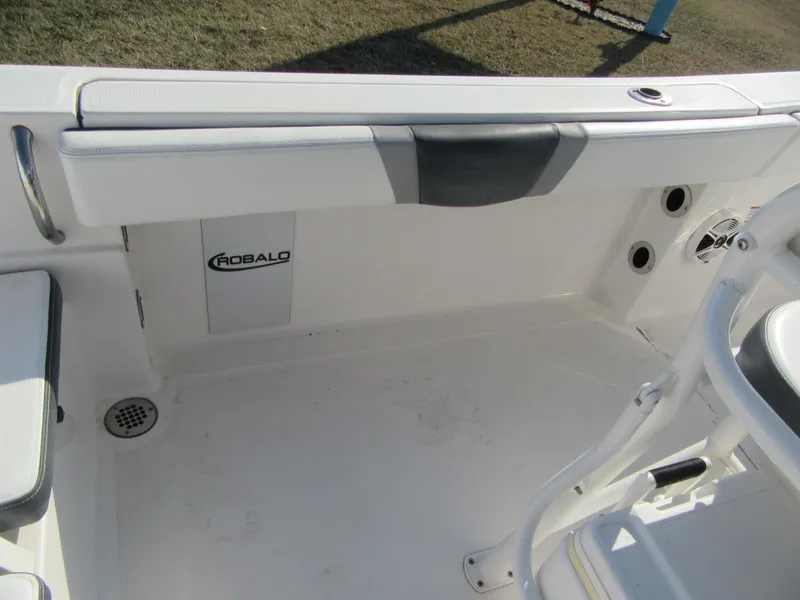Slide: The Image of 2020 Robalo R230 Center Console boat interior, featuring seating and storage area. - 13