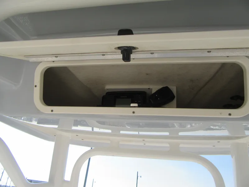 Slide: The Image of 2020 Robalo R230 Center Console storage compartment with electronic equipment inside. - 18