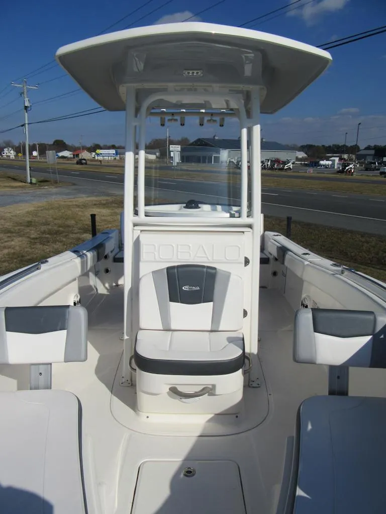Slide: The Image of 2020 Robalo R230 Center Console boat with T-top, white seating, and open deck design. - 24