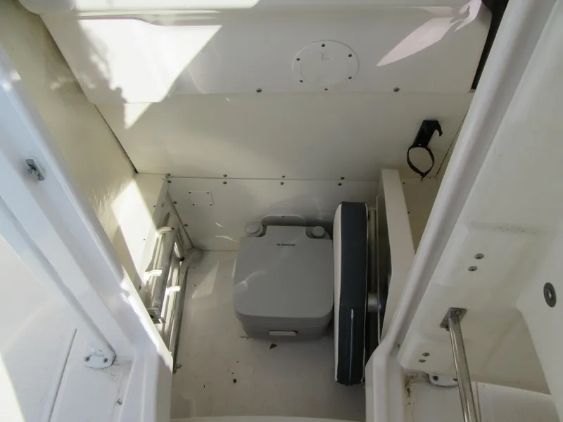 Slide: The Image of 2020 Robalo R230 Center Console boat interior with portable toilet. - 25