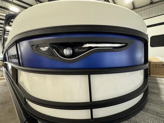 Slide: The Image of Indoor showroom displaying various Bennington pontoon boats, including the 2025 M Swingback 26 MSB model. - 5